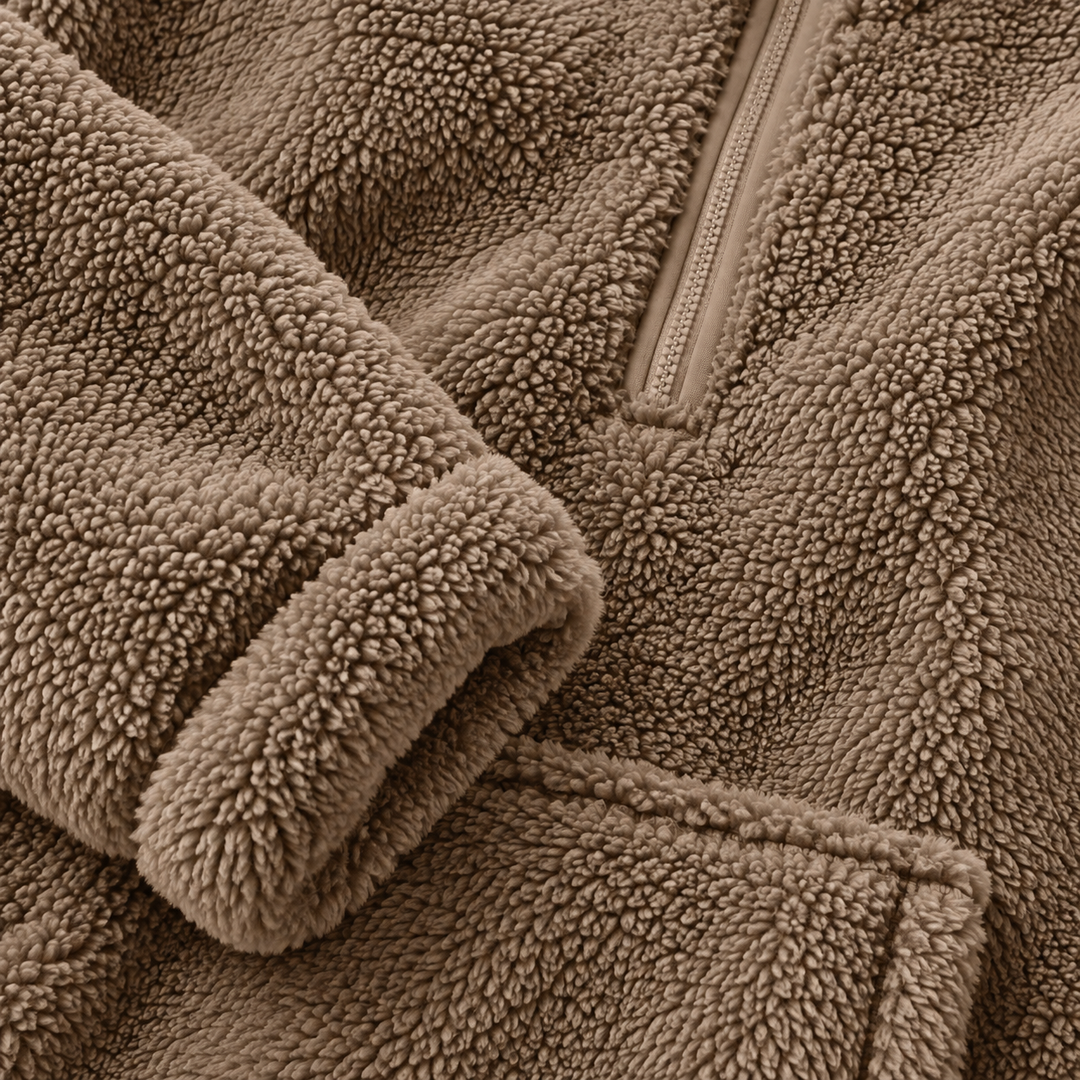 Close-up of caramel fleece texture on the half zip sweater, showing the plush surface, seam detail and zipper area clearly.