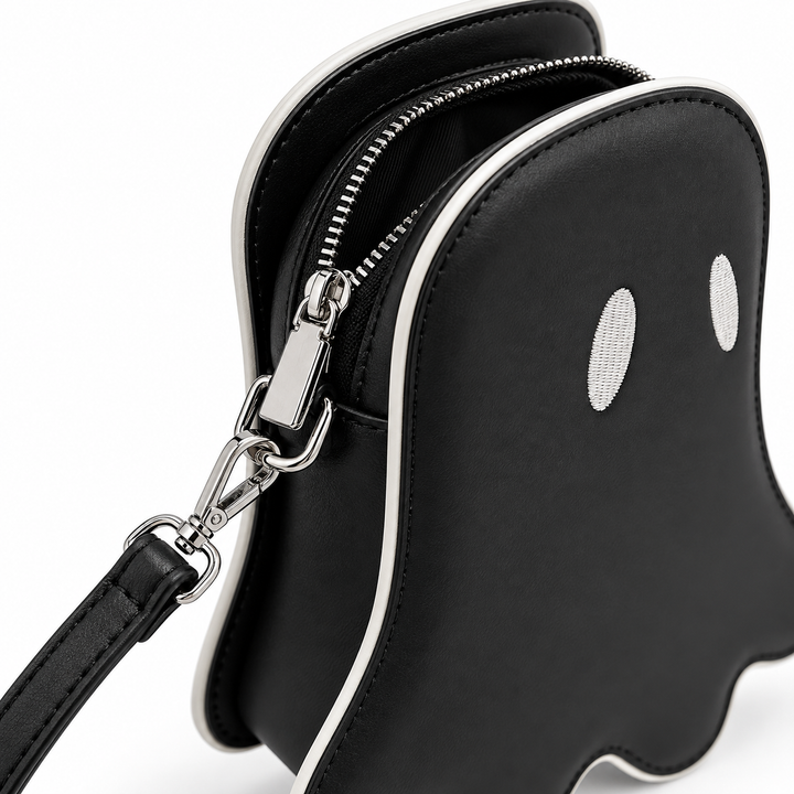 Close-up of black ghost crossbody bag zipper opening, silver clasp hardware, contrast piping and strap attachment