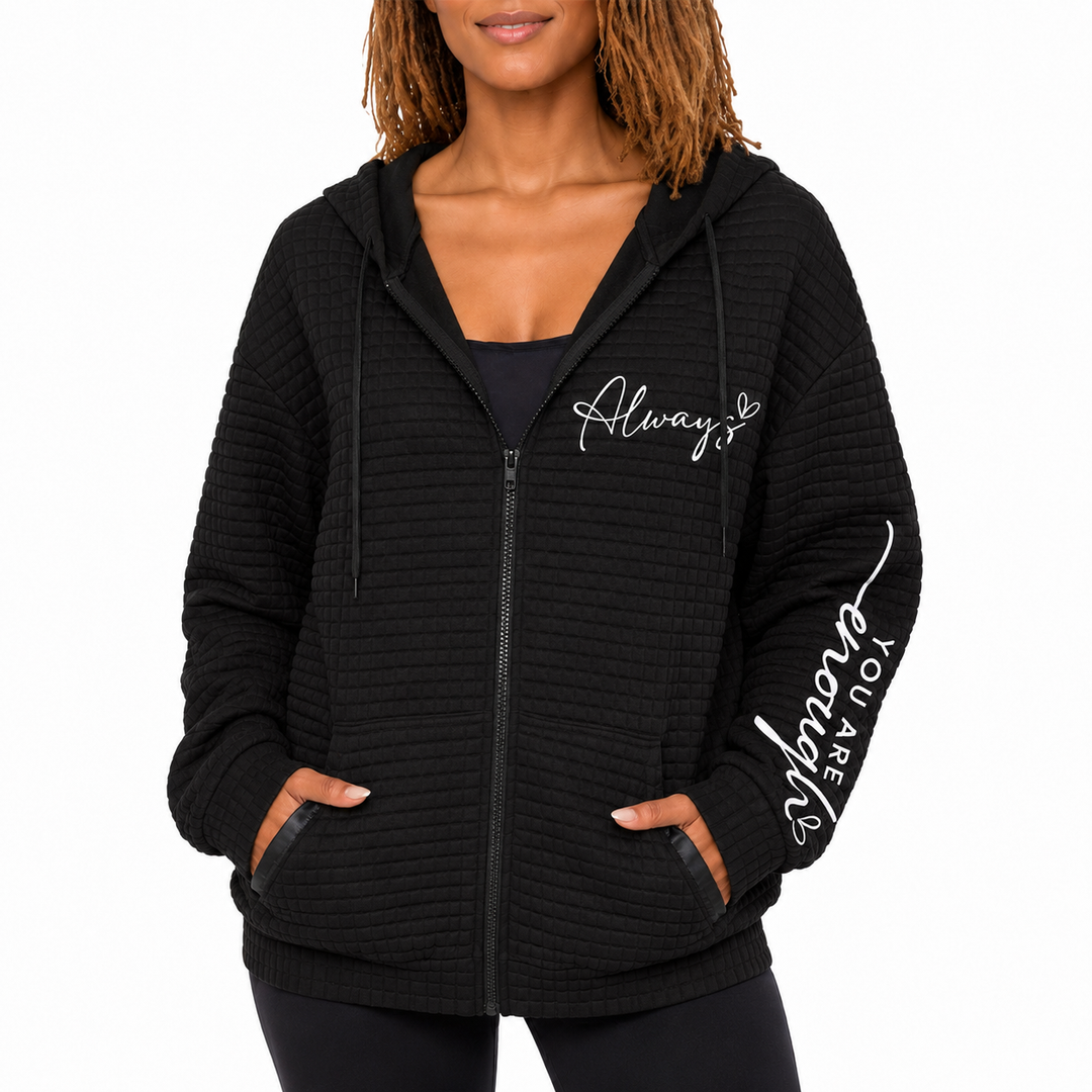 Front black letter zip hoodie with hood, drawstrings, zipper, pockets and sleeve print on white background in studio setting.