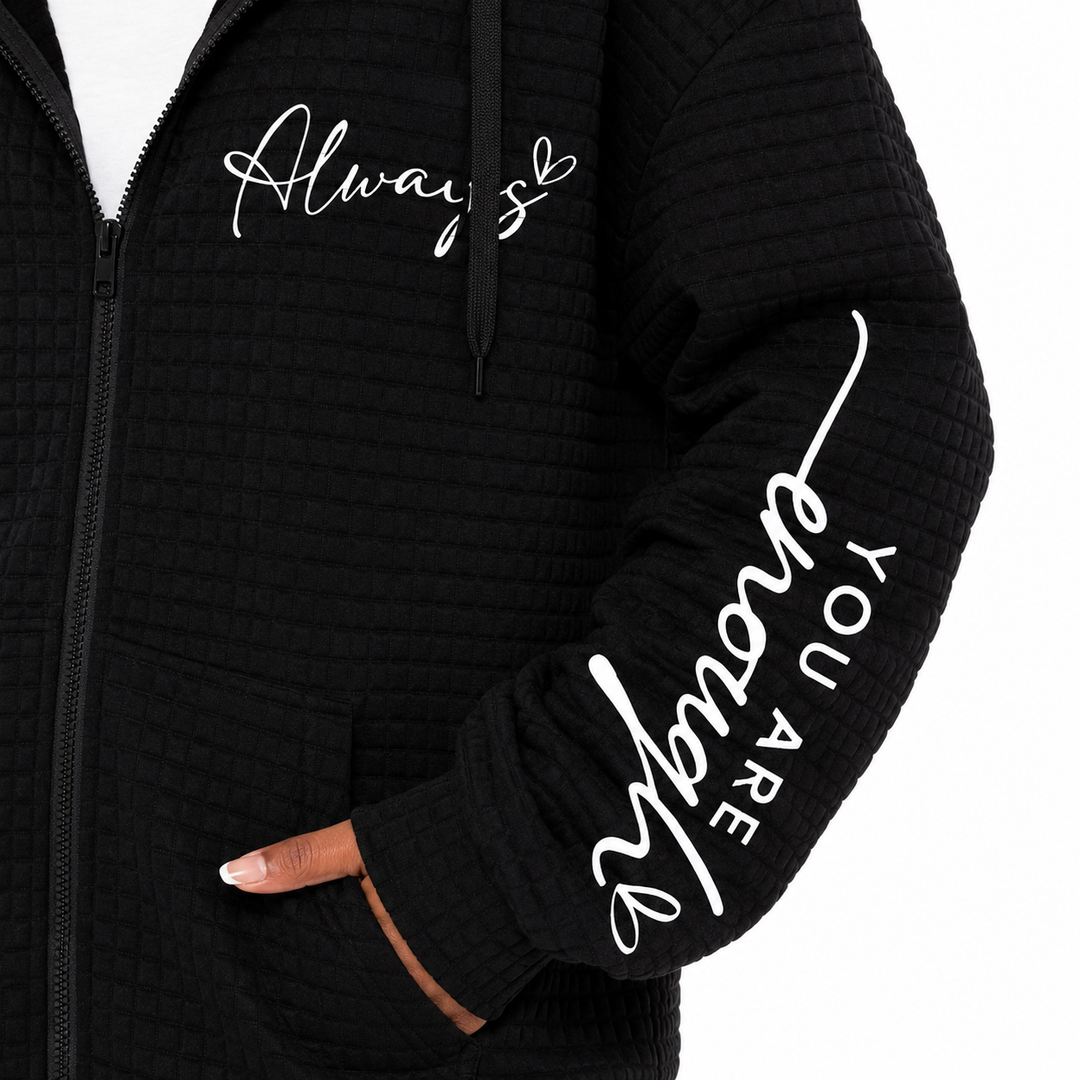 Close-up black letter zip hoodie showing chest script, sleeve lettering, zipper and textured surface on white background view