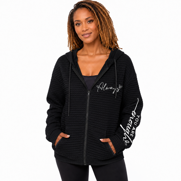 Black letter zip hoodie hero on model showing hood, zipper, pockets, chest script and sleeve lettering on white backdrop set.