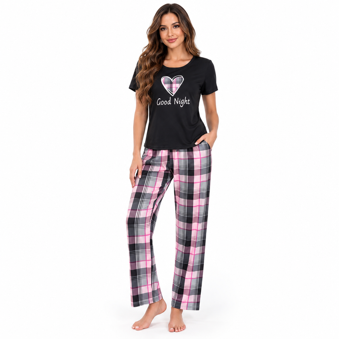 Women's pajama set with black Good Night heart print top and pink black gray plaid long pants on a professional model