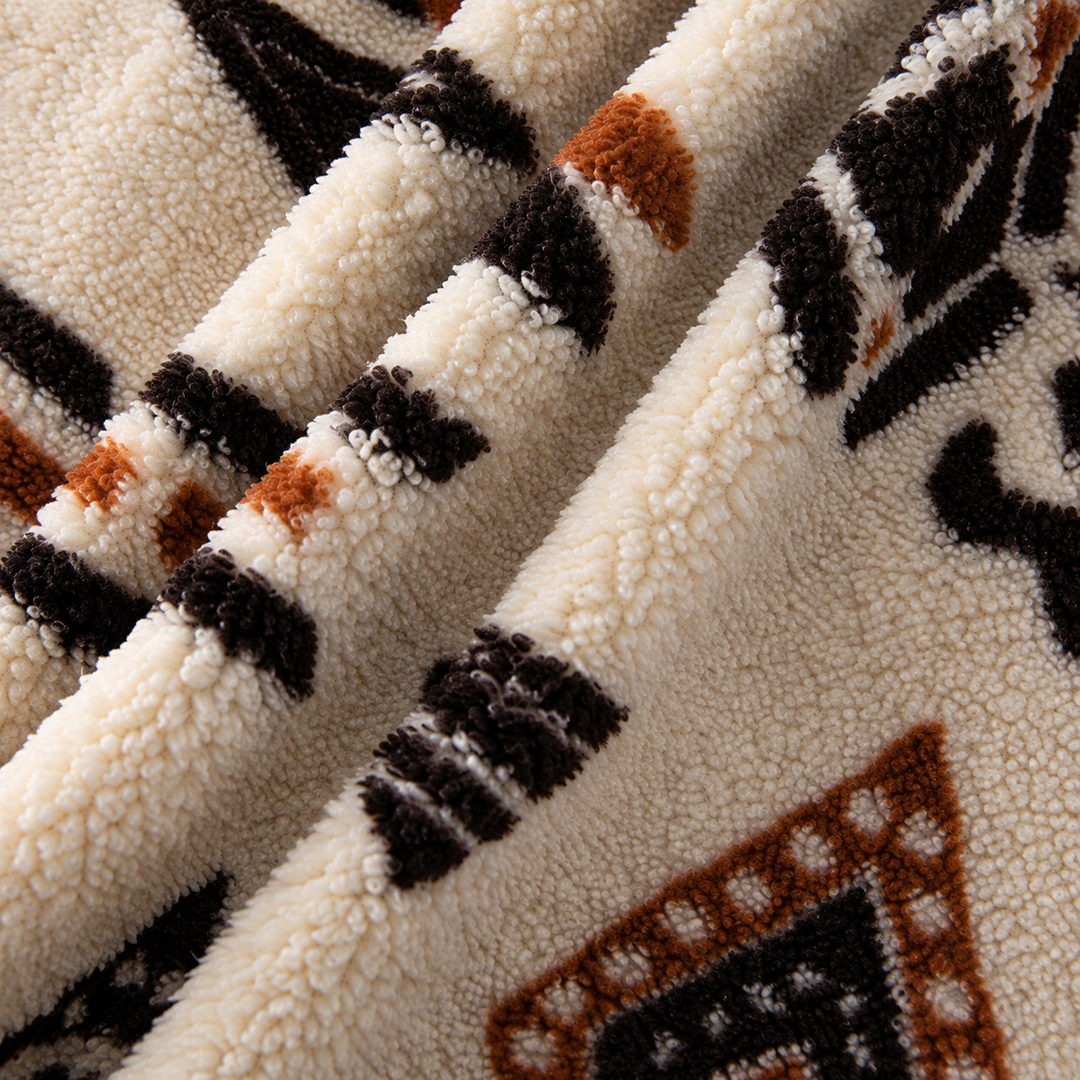 Close-up of the Apricot coat fabric with black and rust geometric print.