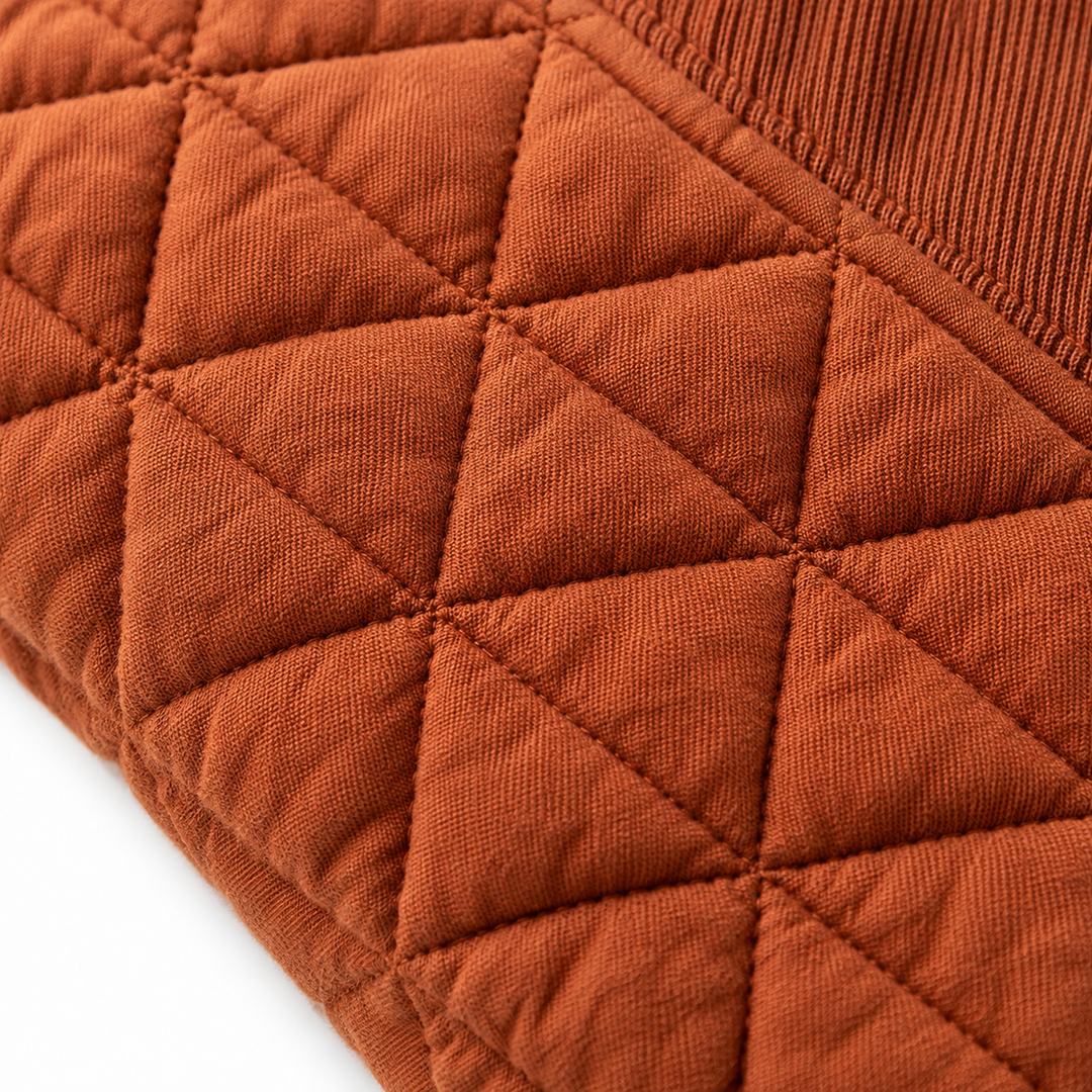Close-up of the Caramel sweatshirt showing geometric quilted stitching, fabric texture, and seam detail.