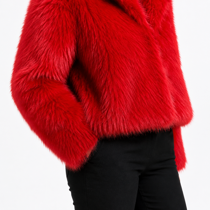 Red cropped faux fur jacket hem close-up showing the boxy cropped edge, side profile and dense red long-pile fiber direction.
