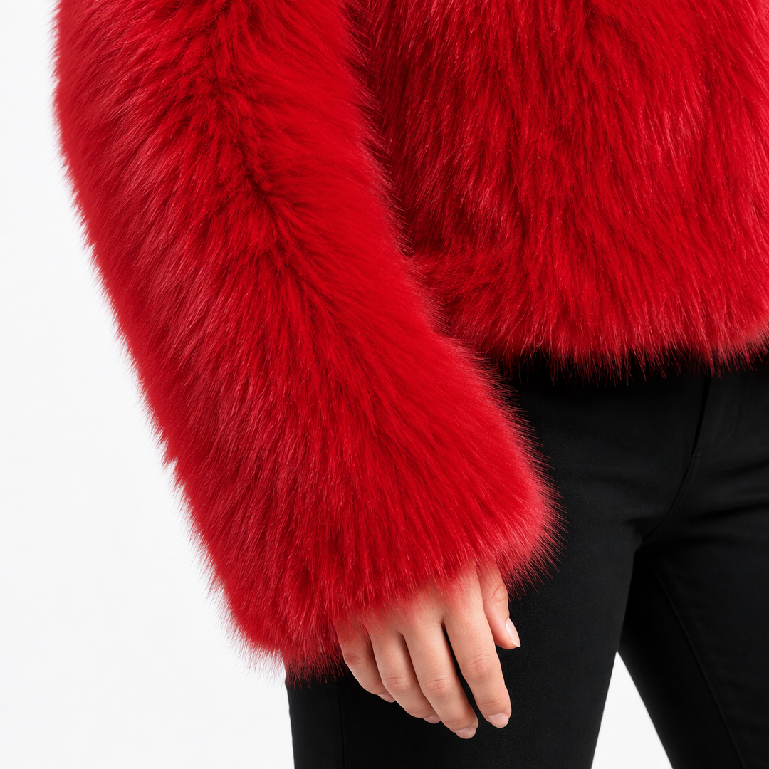 Red cropped faux fur jacket sleeve close-up showing long-pile fibers, cuff edge and finishes beside the model&