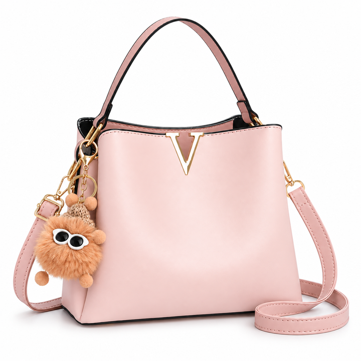 Blush pink shoulder bag with gold V detail and fluffy charm, front view