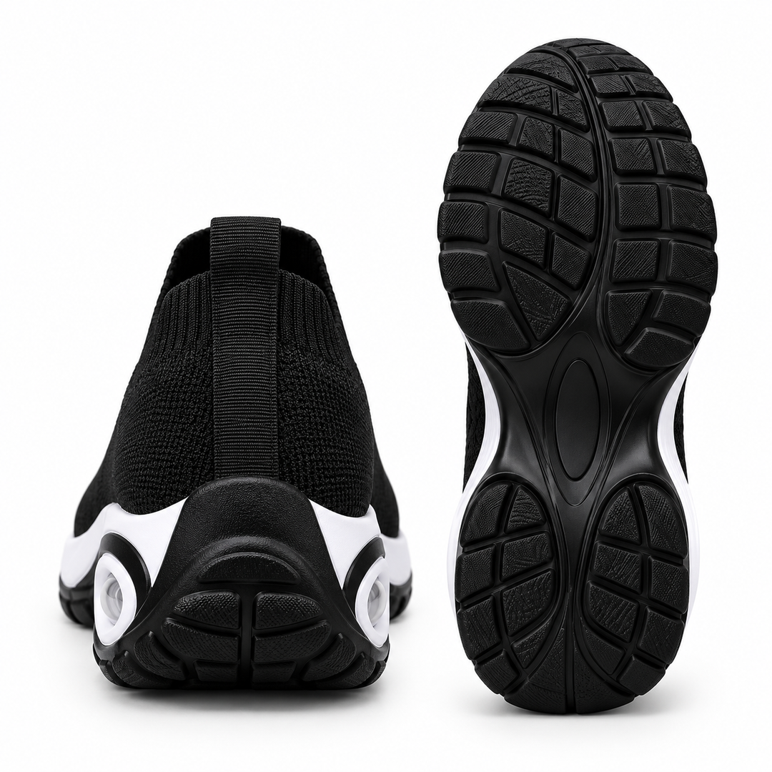 Black slip-on sneakers shown from the rear and outsole, highlighting heel pull tab, black tread pattern and wedge sole shape.