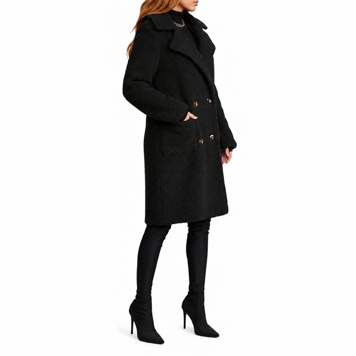Black teddy coat side view on model, highlighting wide lapels, straight proportions, long sleeves and textured outer surface.