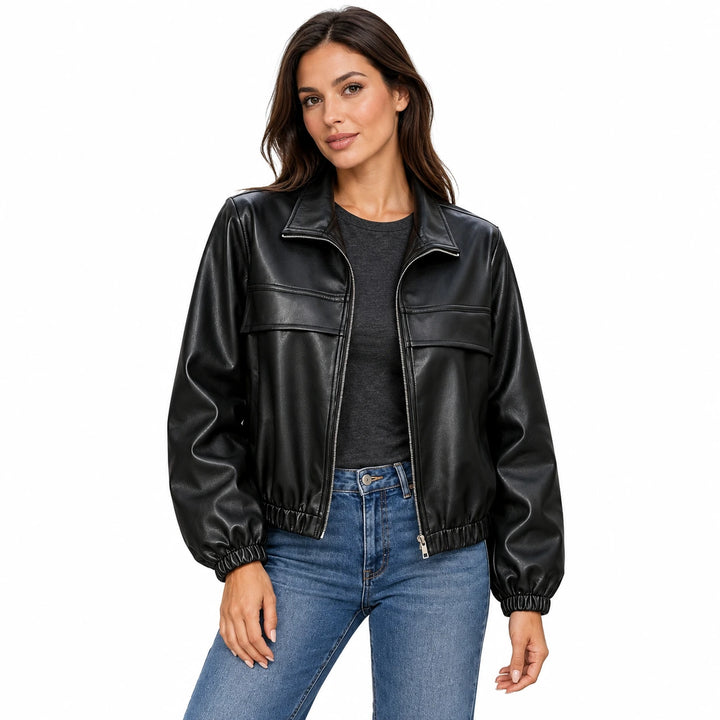 Woman wearing the black vintage faux leather jacket with a charcoal top and blue jeans.
