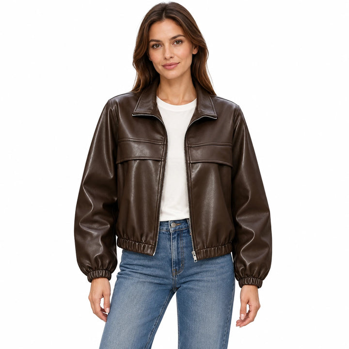 Woman wearing the Brown faux leather jacket with an ivory T-shirt and blue jeans on a white background.