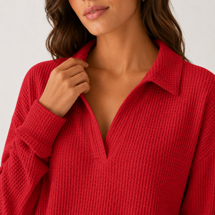 Red V-neck collared long sleeve top close-up shows waffle texture, neckline placket collar detail and sleeve cuff on a model.