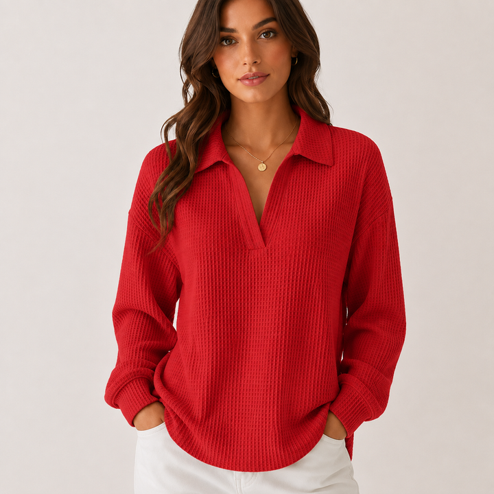 Red long sleeve collared waffle top on a model, showing the V-neck opening, loose silhouette, cuffs and curved hem in studio.