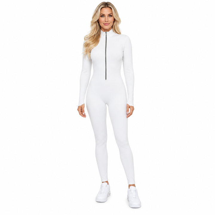 White jumpsuit on a blond adult model, shown head to toe with a stand collar, long sleeves and white trainers on a white set.